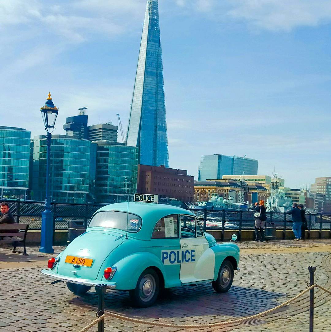 A vintage police car in London, with the Shard behind. 