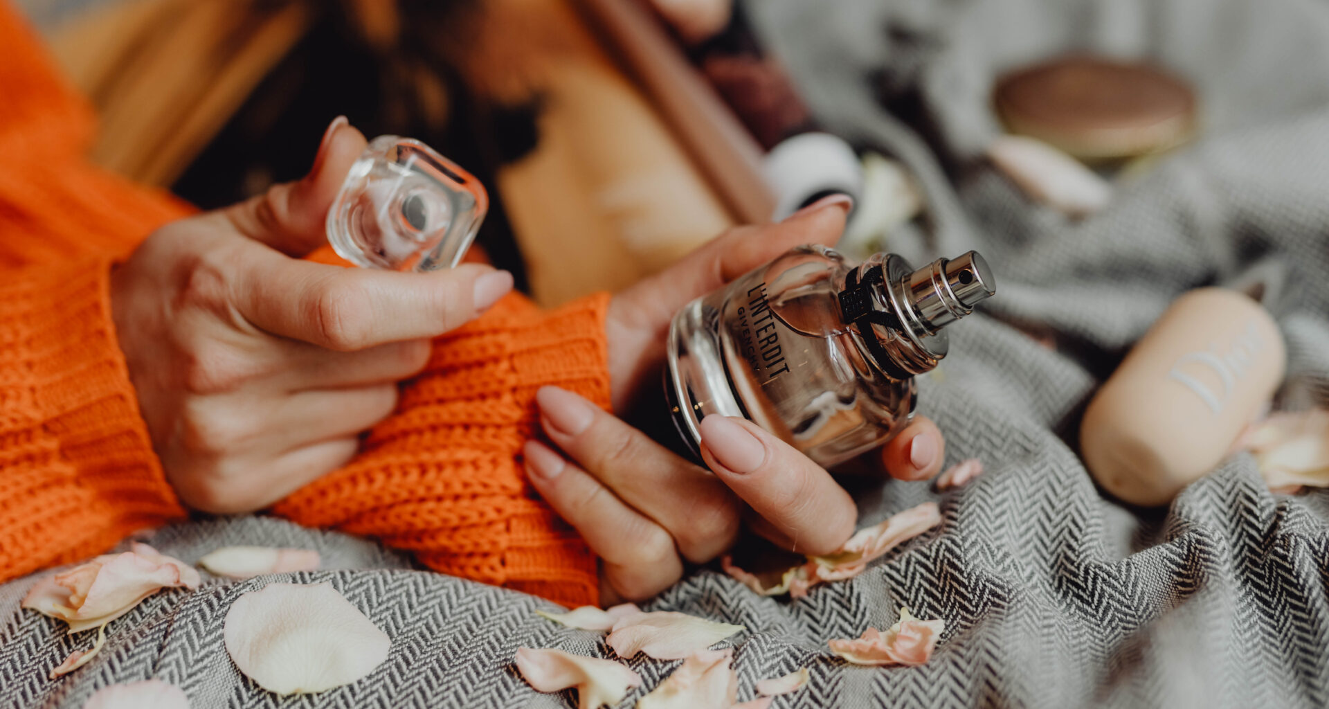 woman holding bottle of givenchy perfume