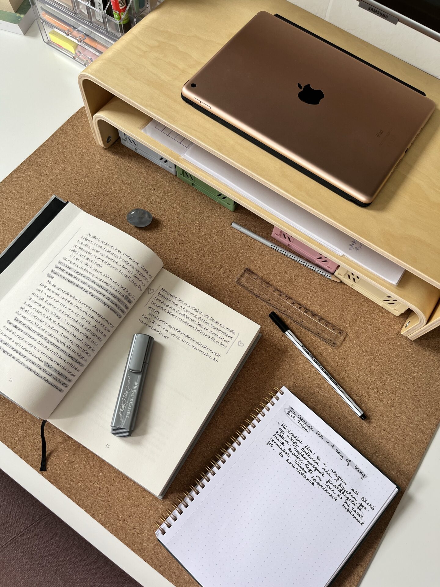desk flatlay with ipad, stationery, open book with notes.