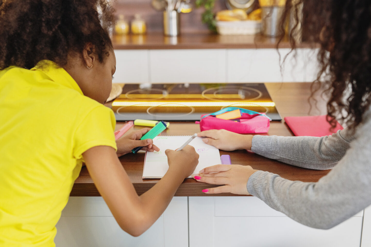 mother helping her daughter study at home