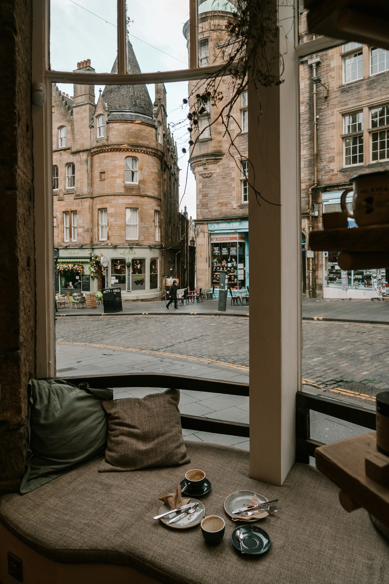 a window seat in a cafe overlooking old buildings.