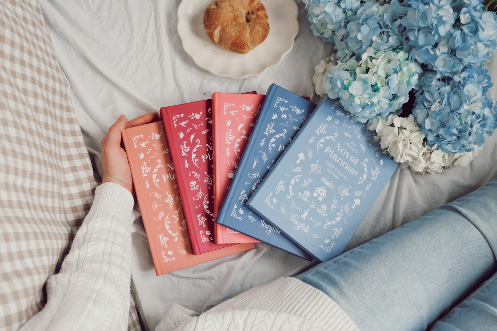 beautiful books on bed with flowers and pastry