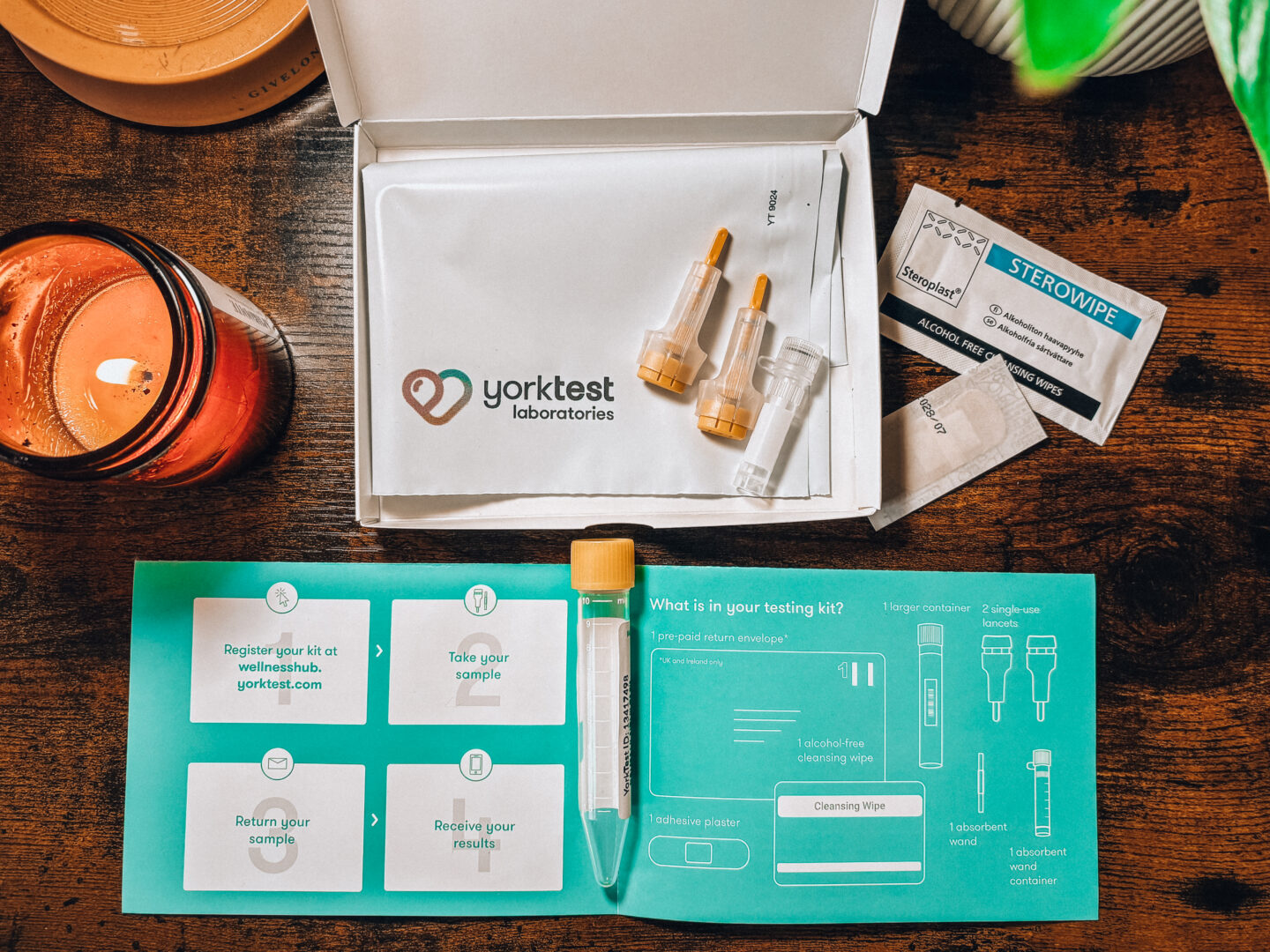 items inside the yorktest premium food intolerances test kit displayed on a table with a candle.