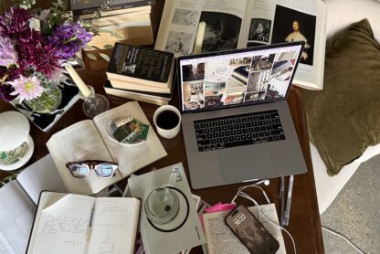 desk with notebooks coffee and laptop doing research