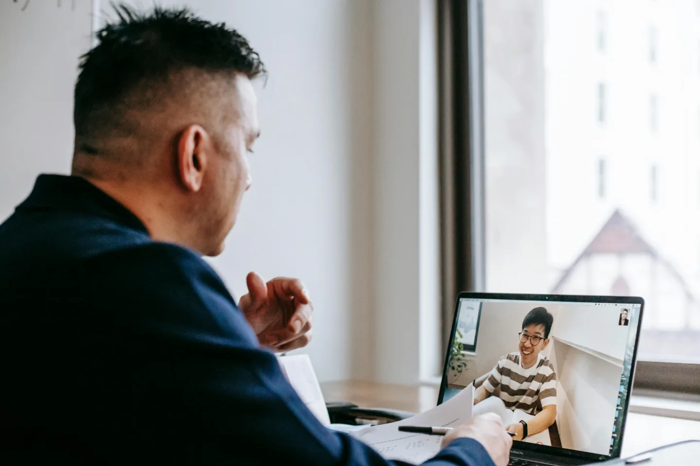 man looking at computer screen on video call