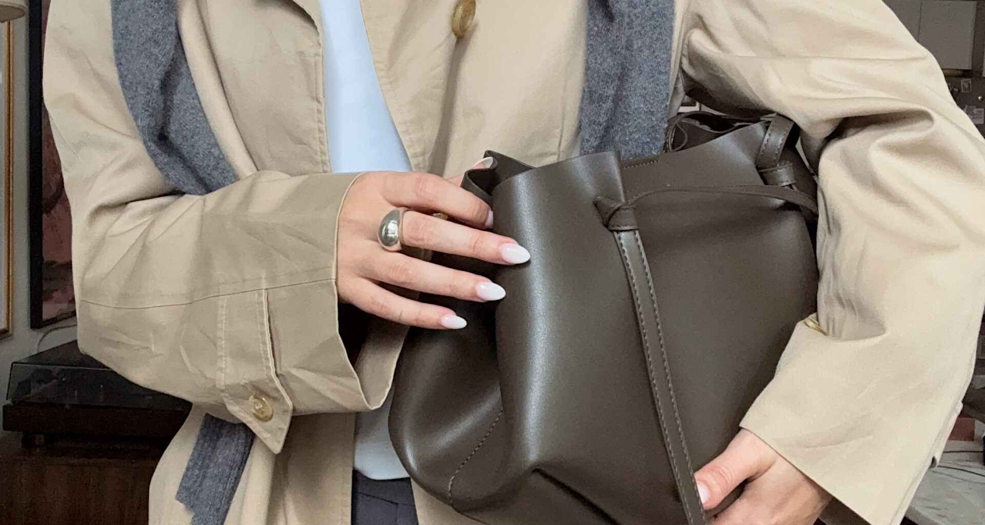 Fashionable woman wearing trench coat holding bag