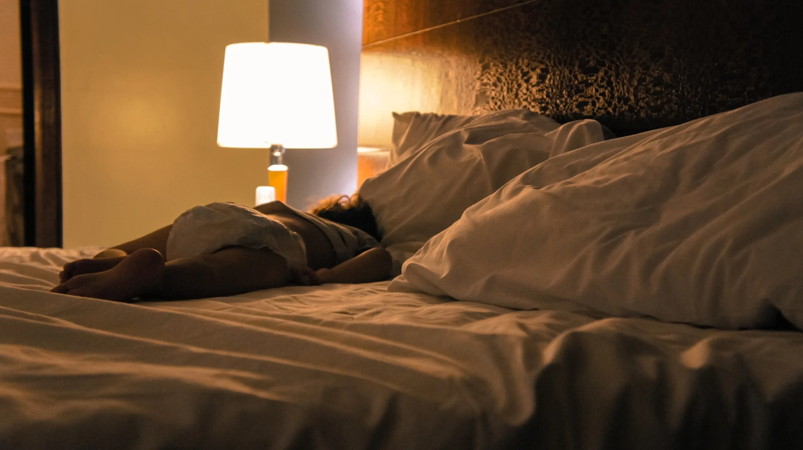 child sleeping next to lamp